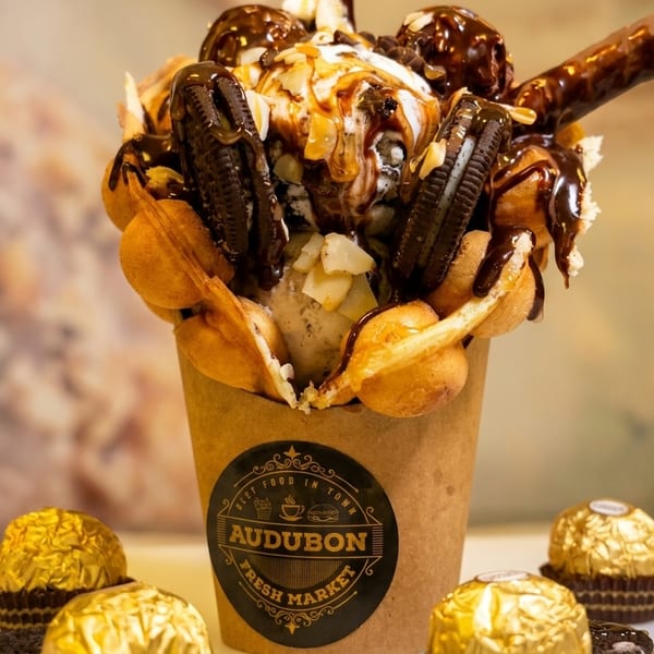 Bubble waffle cone from Audubon Fresh Market filled with ice cream, cookies, and chocolate syrup.