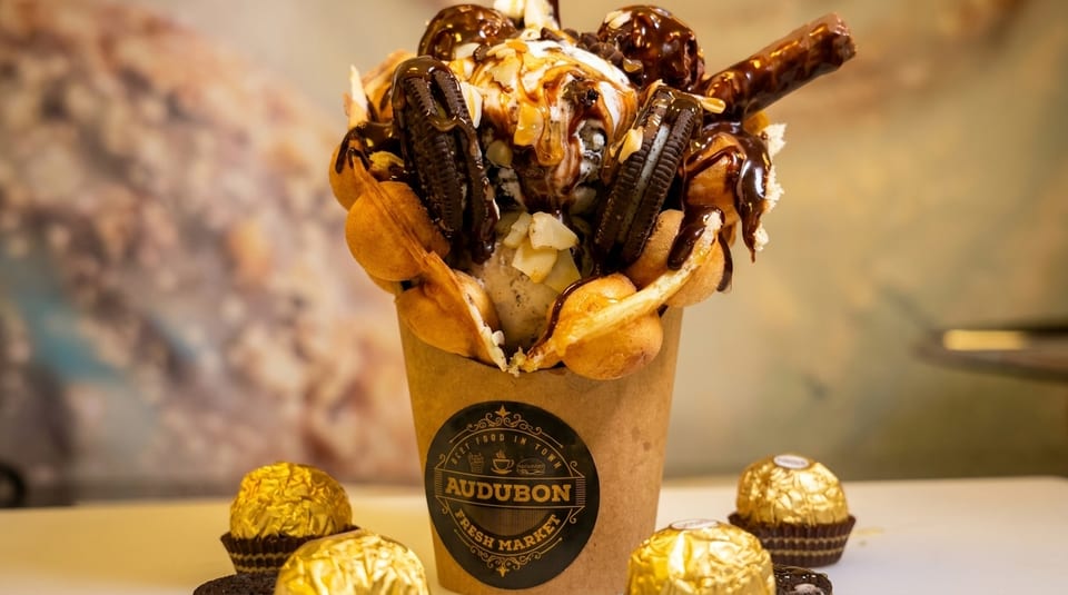 Bubble waffle cone from Audubon Fresh Market filled with ice cream, cookies, and chocolate syrup.