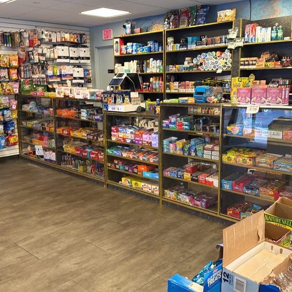 A convenience store interior with shelves stocked with snacks, drinks, and various products.